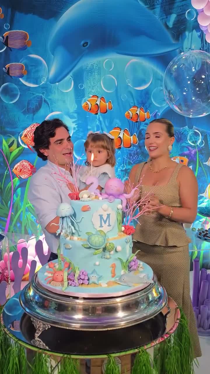 Família reunida ao redor do bolo de aniversário infantil