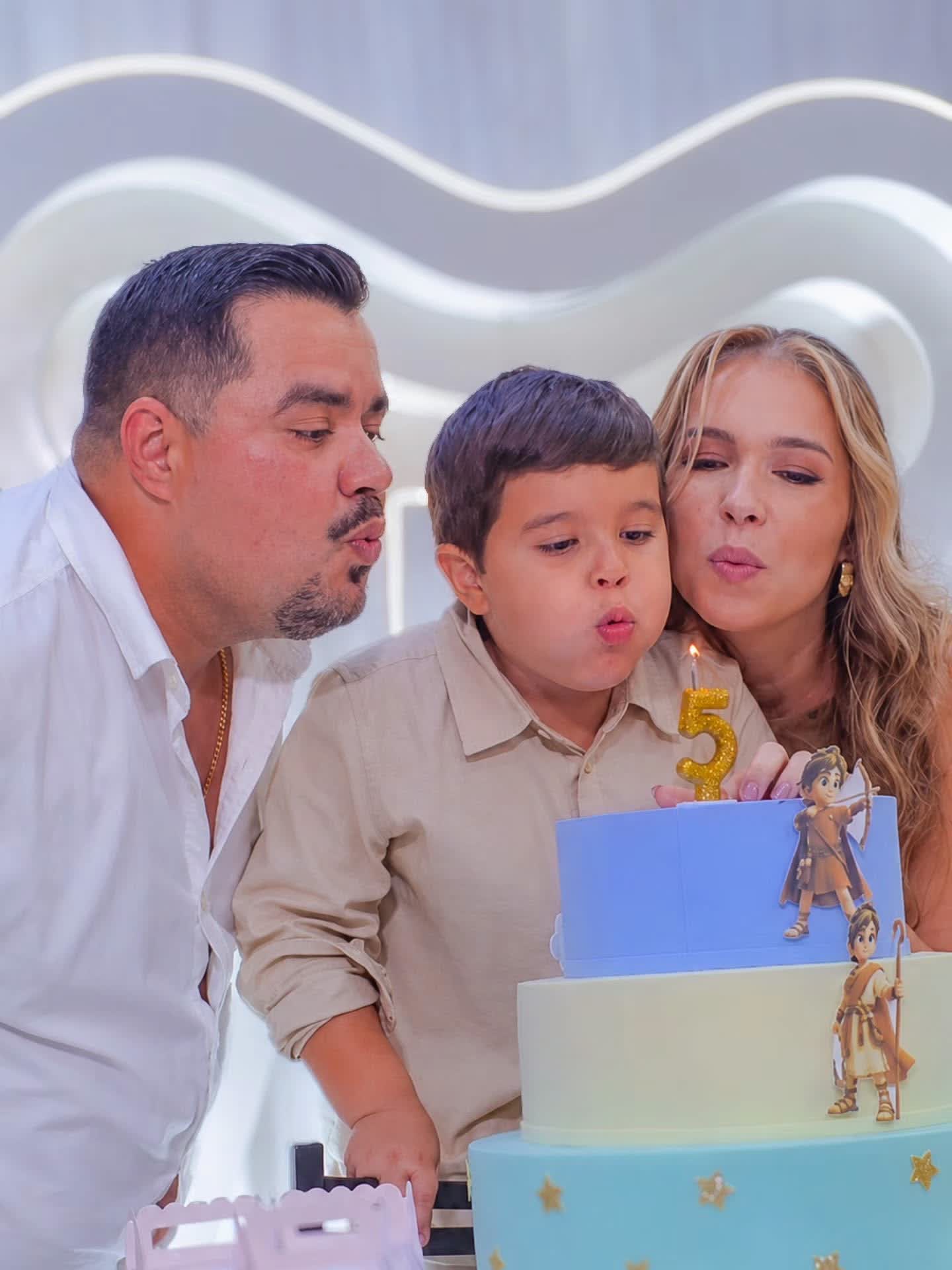 Família soprando a velinha do bolo de aniversário