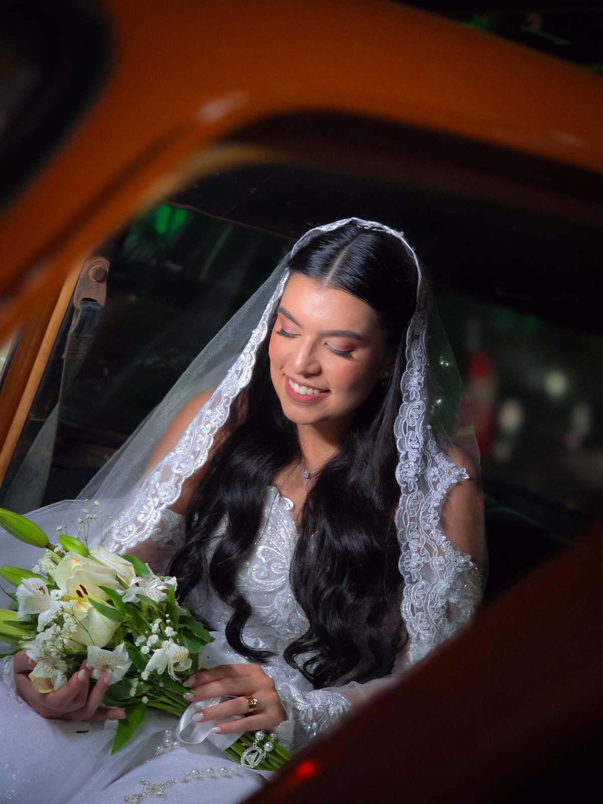 Noiva sorrindo dentro do carro à noite